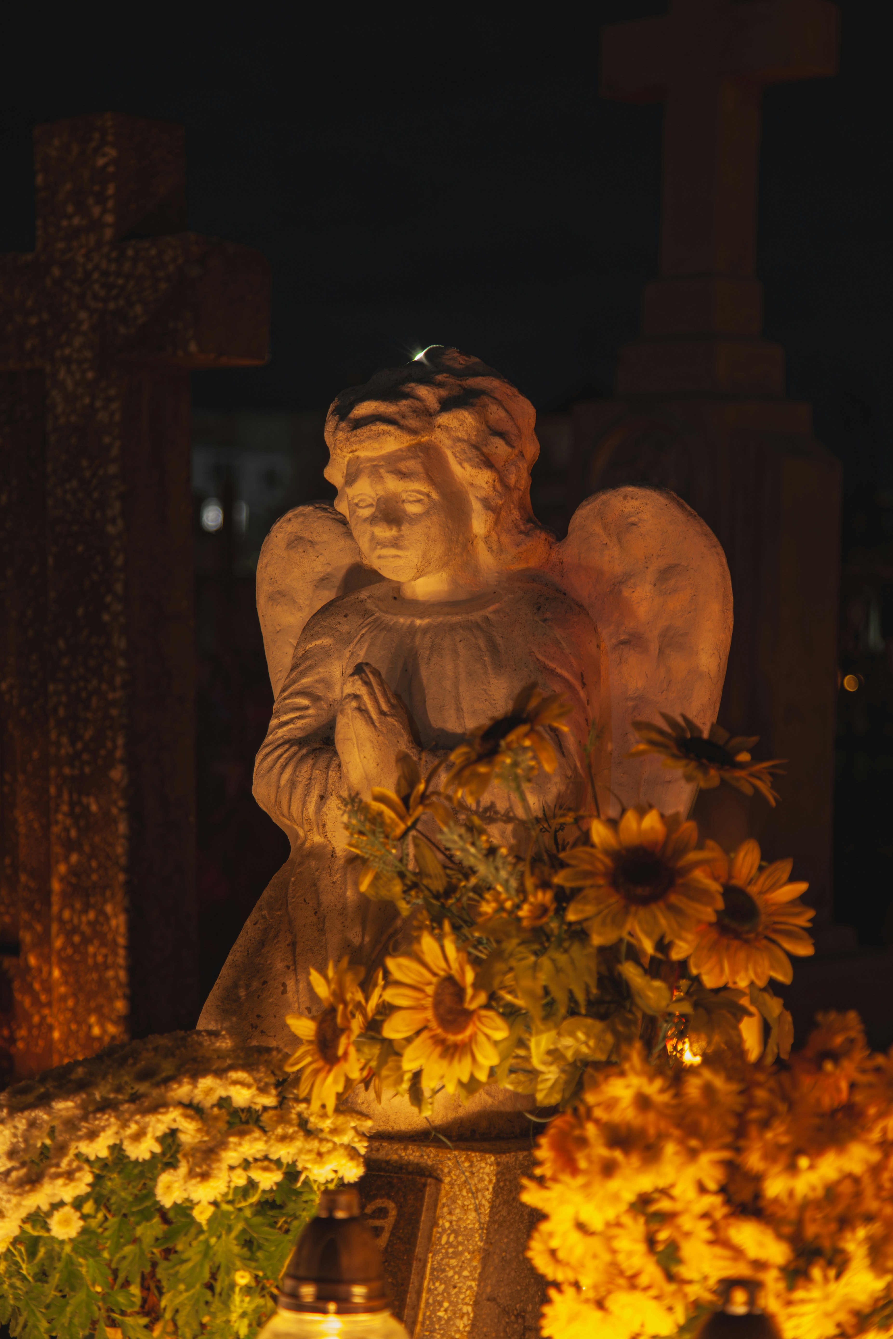 a statue of an angel holding a bouquet of sunflowers