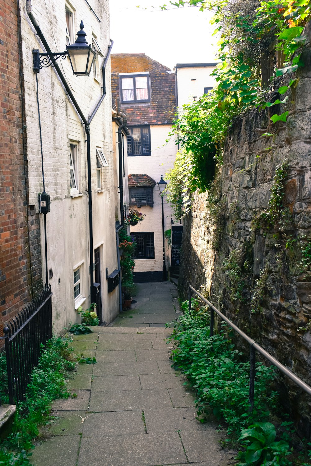 a narrow alley way with a lamp post on the side