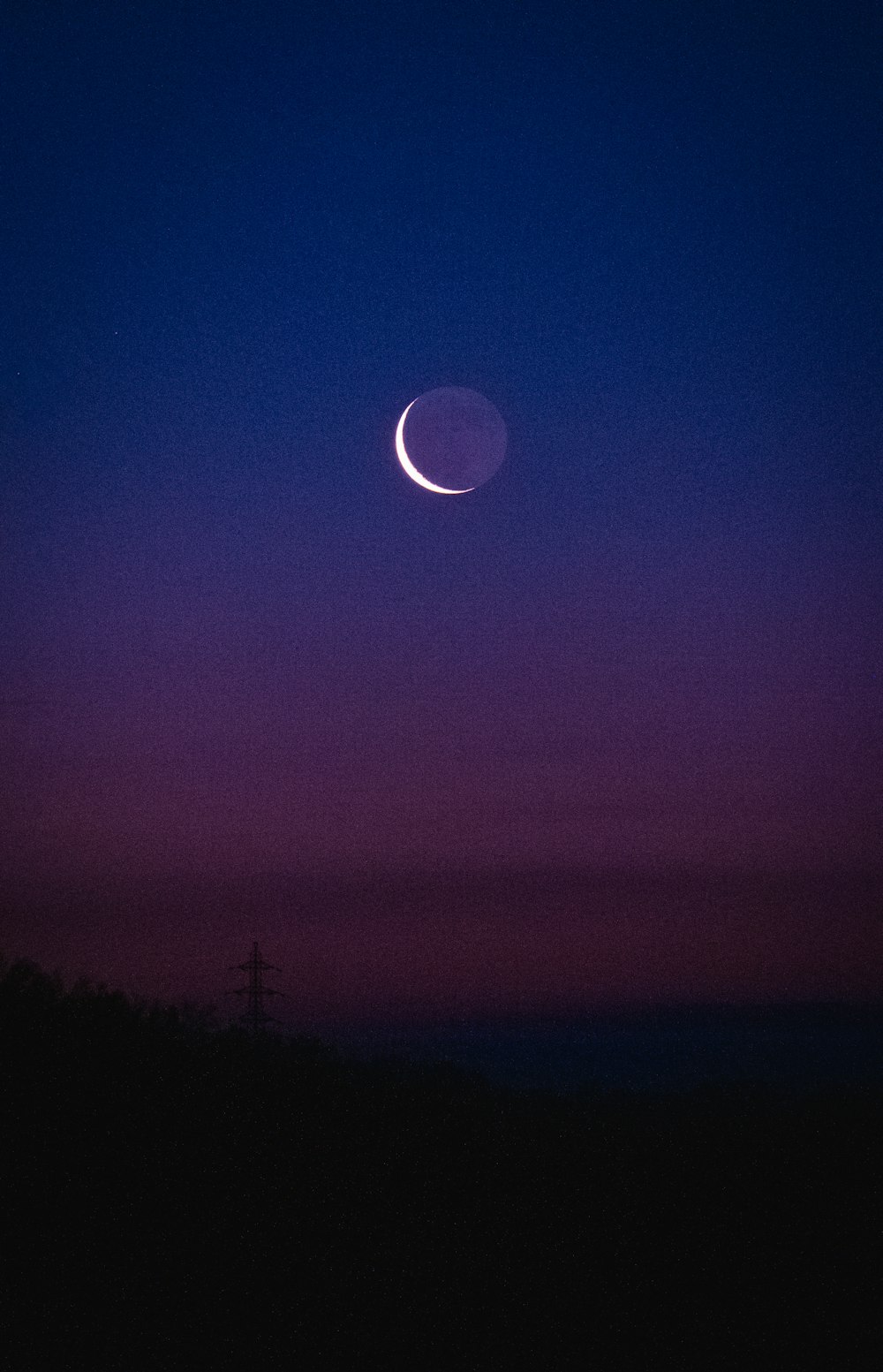 a crescent is seen in the night sky