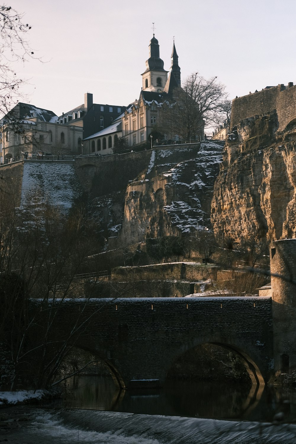 un château sur une colline avec un pont en face