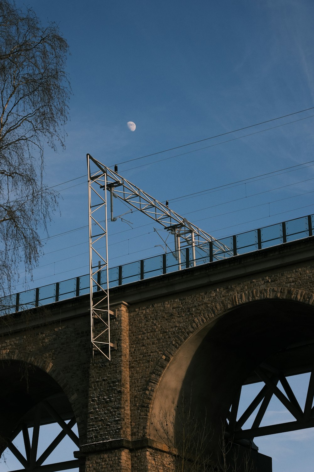 un pont ferroviaire avec une pleine lune en arrière-plan