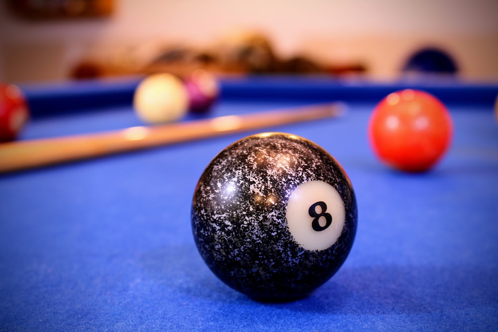 une table de billard avec une boule de billard et des queues