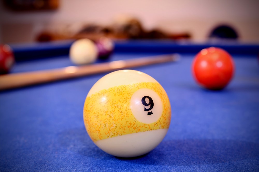 une table de billard avec une boule de billard et des queues