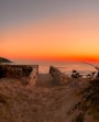 a wooden bench sitting on top of a sandy beach