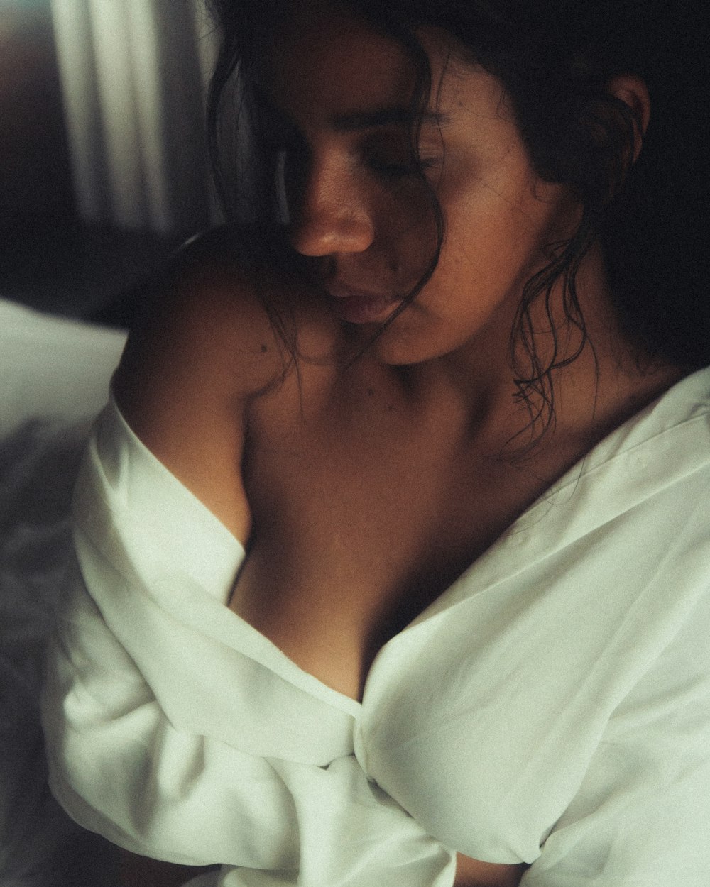 a woman in a white shirt laying on a bed