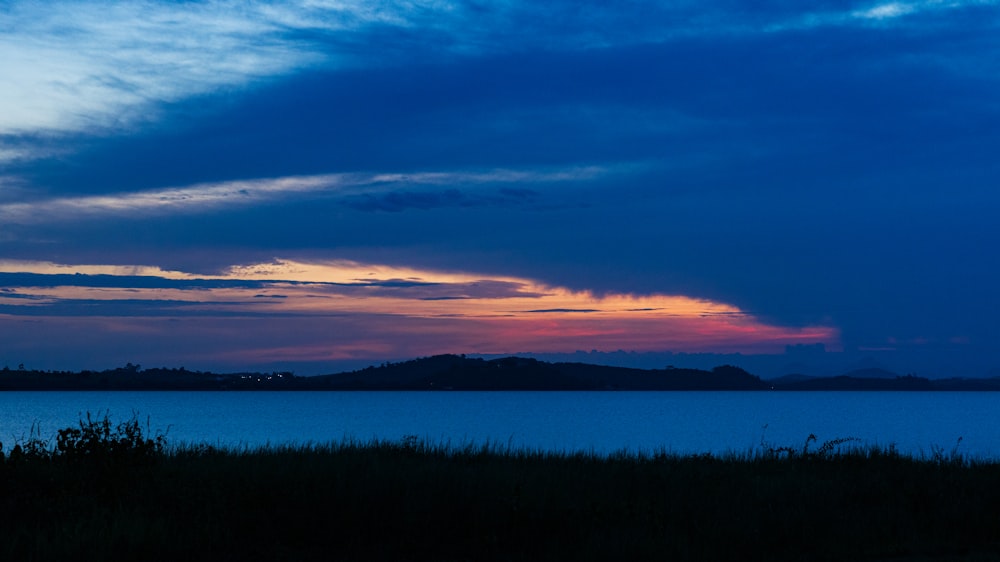 a large body of water sitting under a cloudy sky