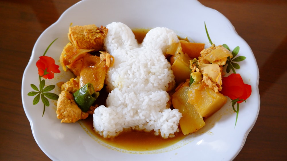 a white plate topped with rice and vegetables