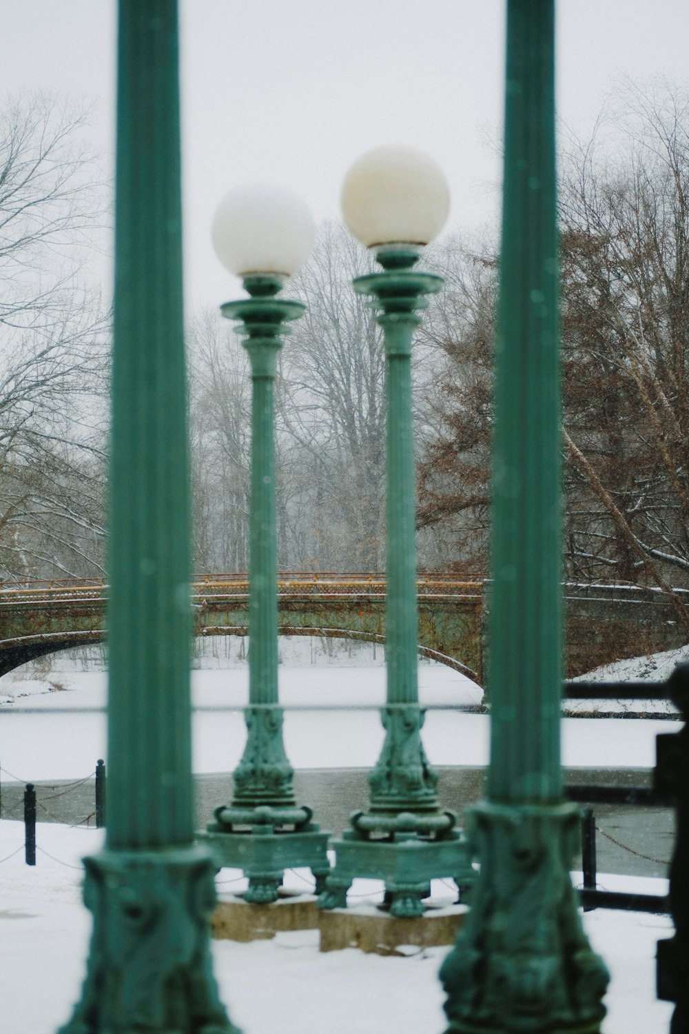 a couple of green street lamps sitting in the snow