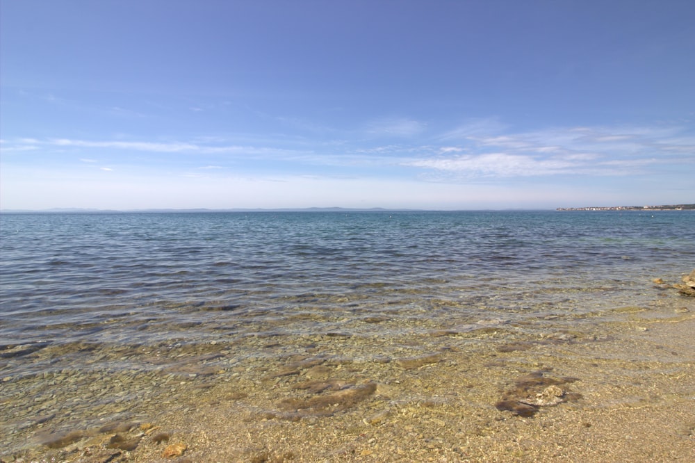 a body of water sitting next to a sandy beach