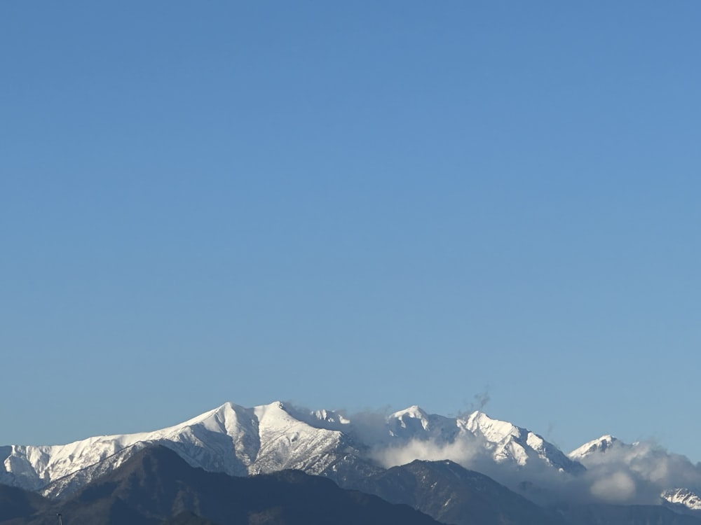 a plane flying over a snow covered mountain range