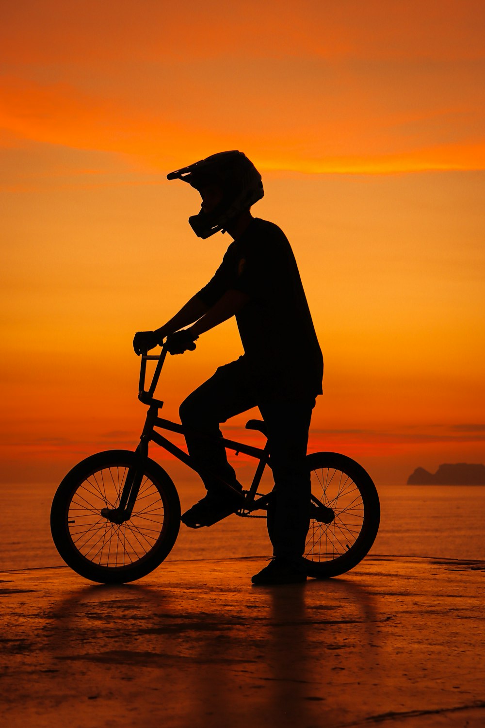 a man riding a bike on top of a beach