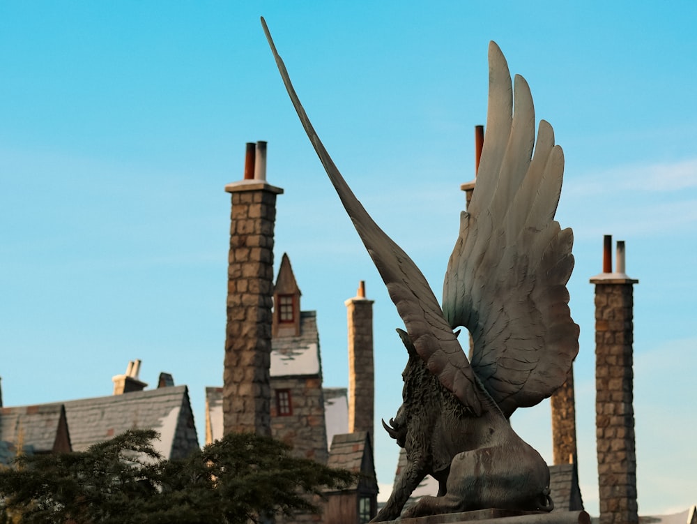 a statue of a winged bird on top of a building