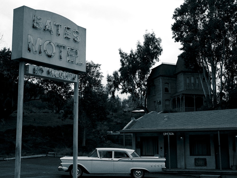an old car is parked in front of a motel