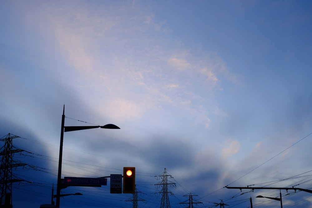 a traffic light sitting under a cloudy blue sky