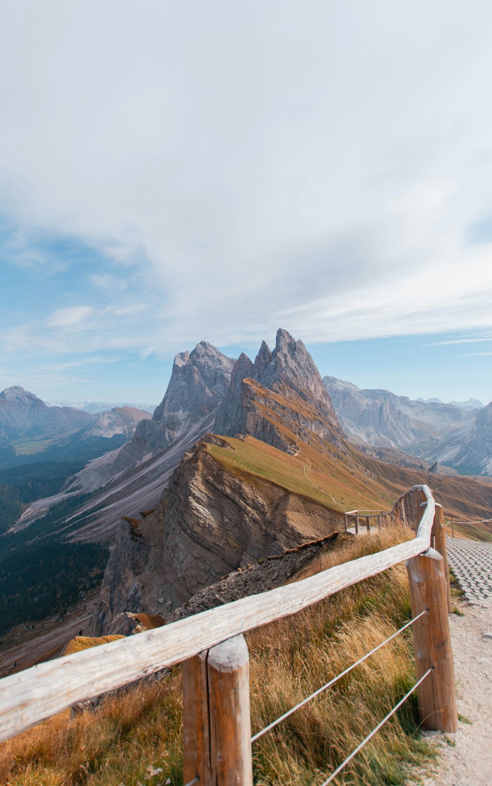 a wooden fence overlooks a mountain range