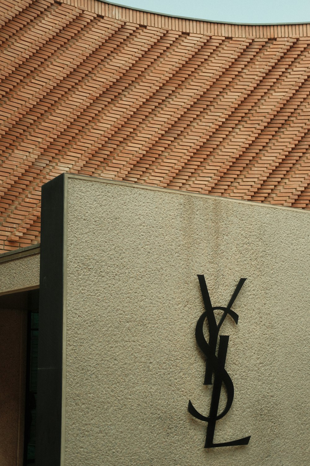 a sign on the side of a building with a sky background