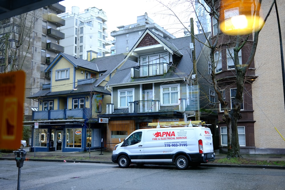 a van parked in front of a row of houses