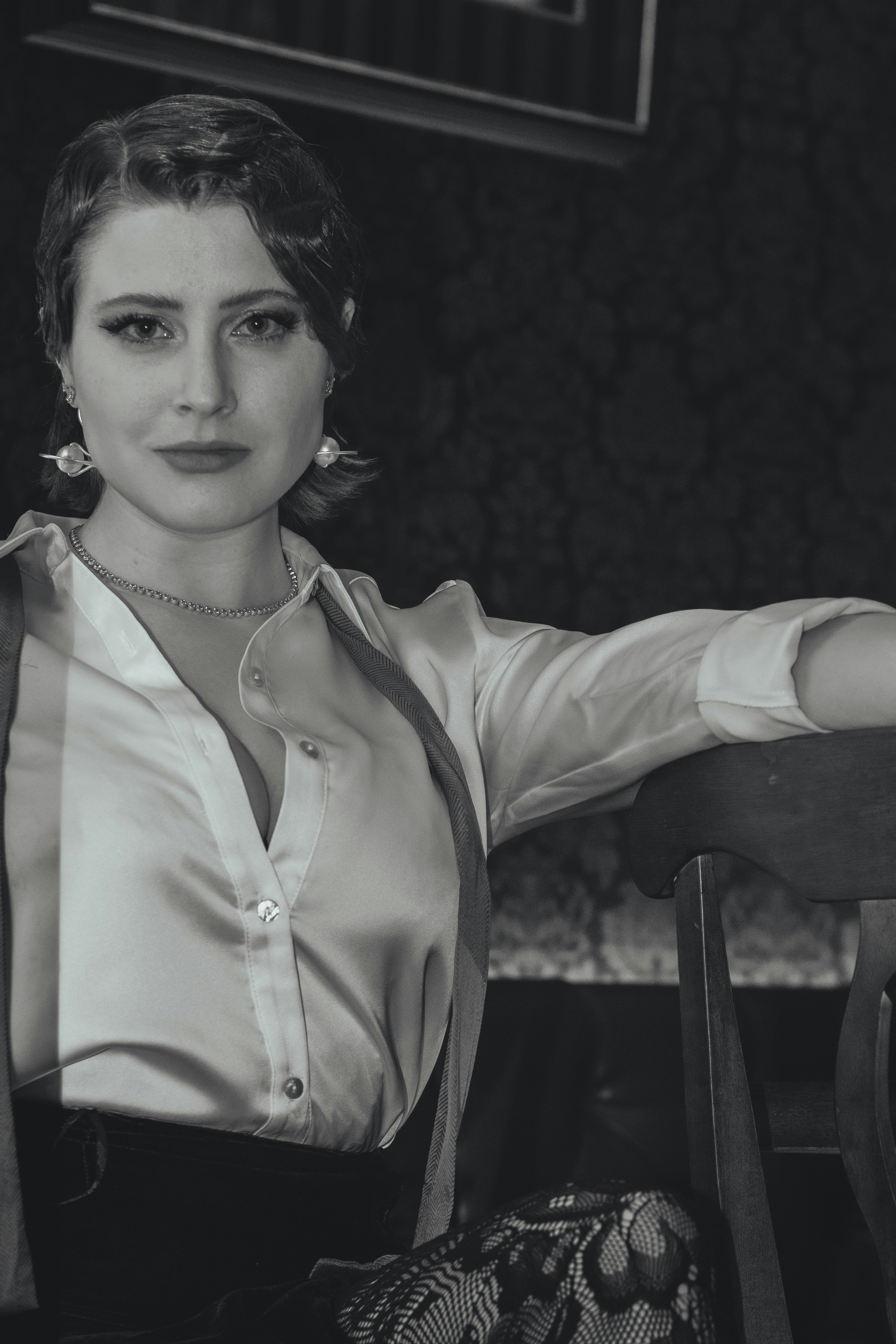 a black and white photo of a woman sitting at a table