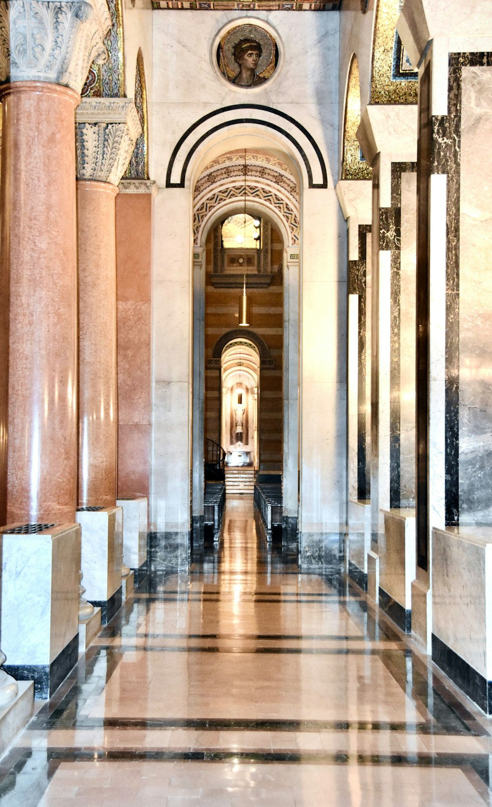 a hallway with marble columns and a clock on the wall