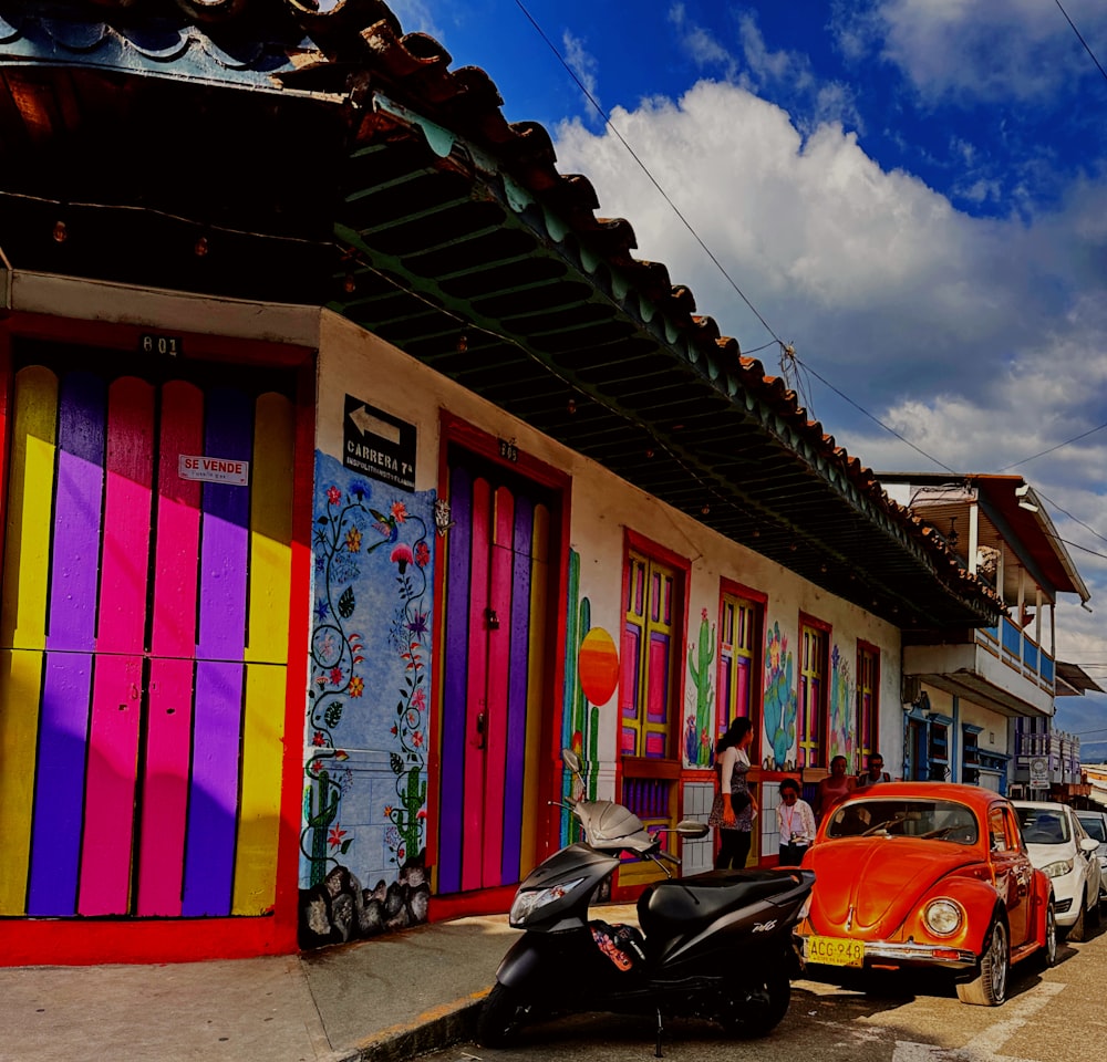 a row of parked cars in front of a colorful building
