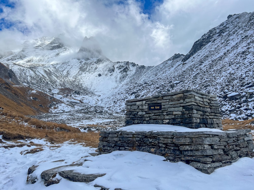a stone structure in the middle of a snowy mountain