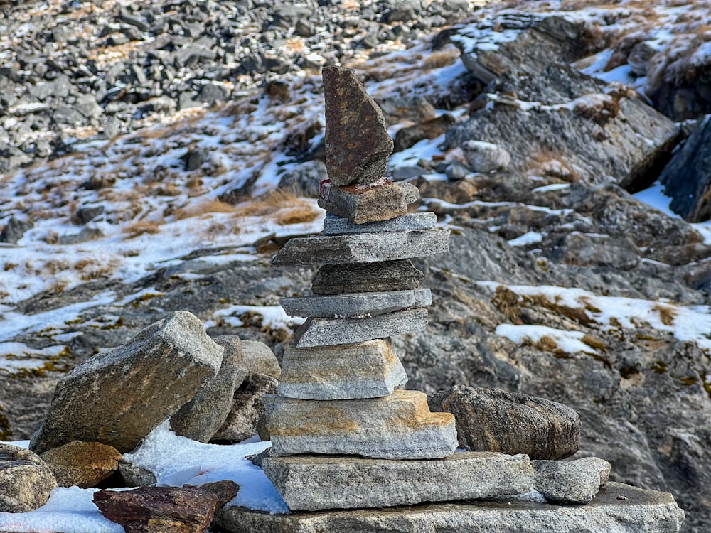 uma pilha de rochas sentada em cima de um chão coberto de neve