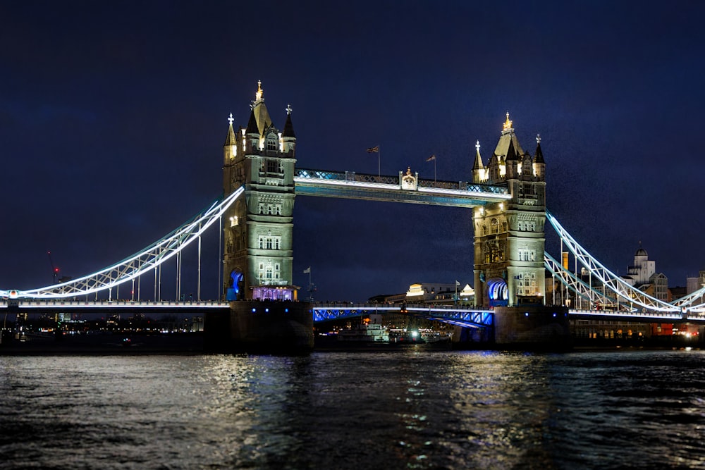 the tower bridge is lit up at night