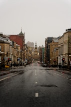 an empty city street with buildings and a traffic light