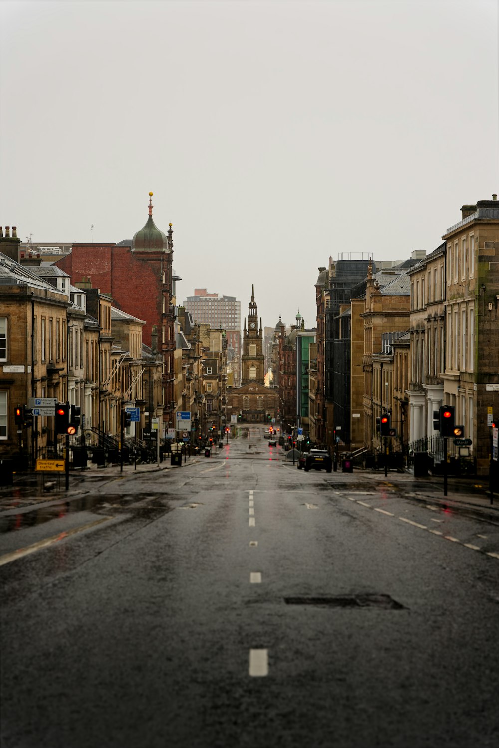 an empty city street with buildings and a traffic light