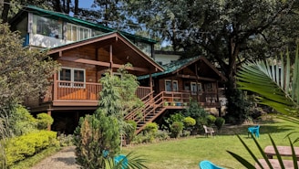 a wooden house with a green roof surrounded by trees
