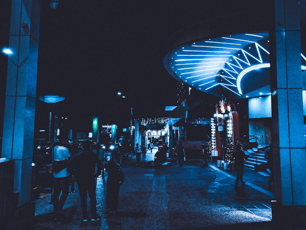 a group of people walking down a street at night