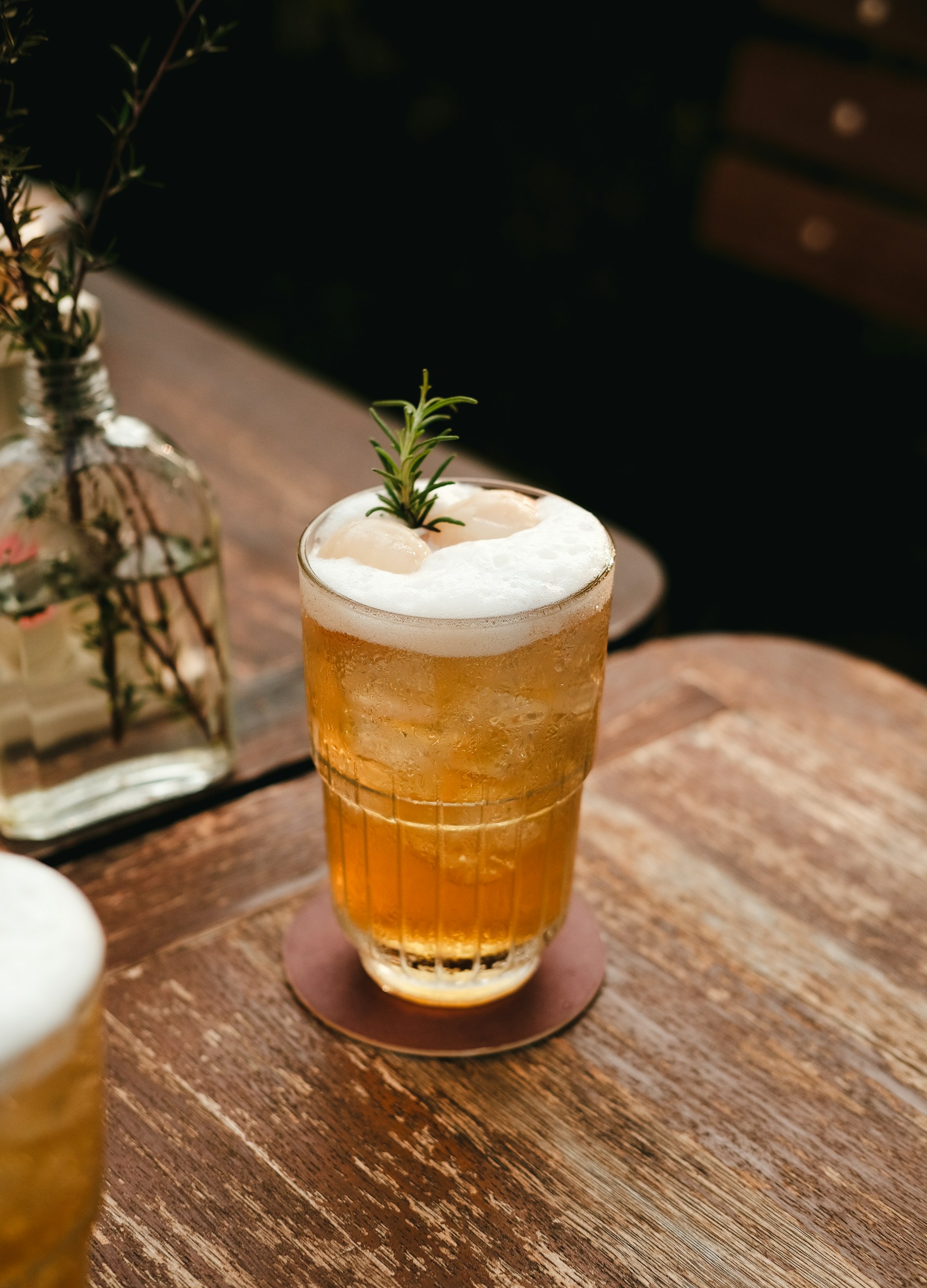 a glass of beer sitting on top of a wooden table
