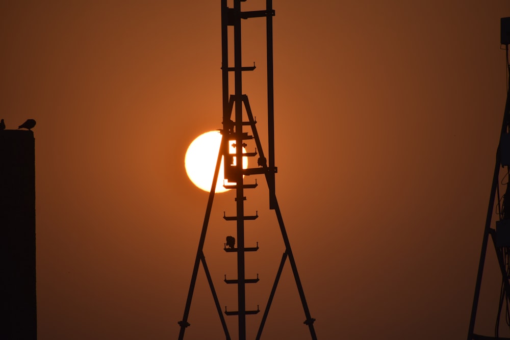 Le soleil se couche derrière une haute tour