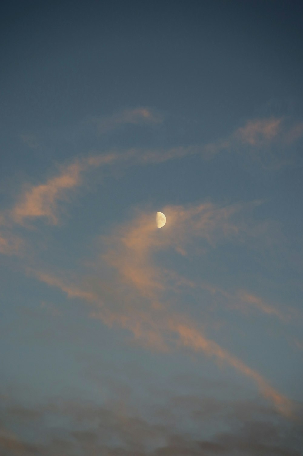 the moon is seen through the clouds in the sky