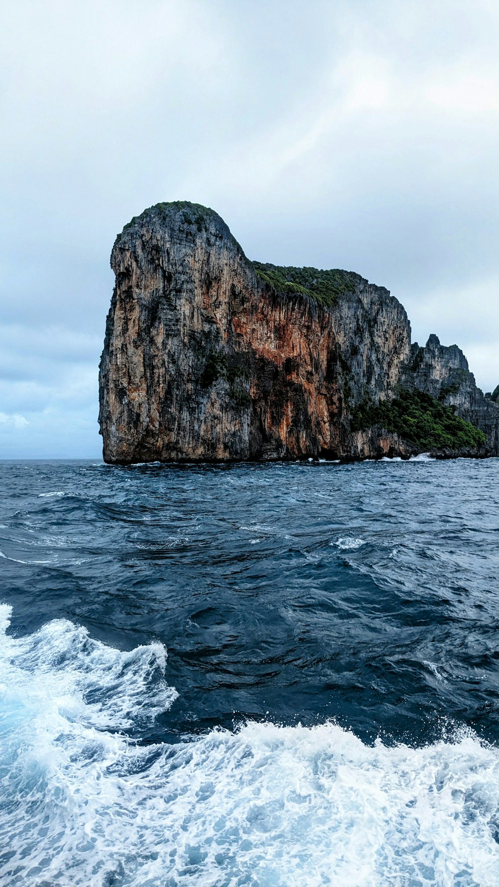 a large rock in the middle of the ocean