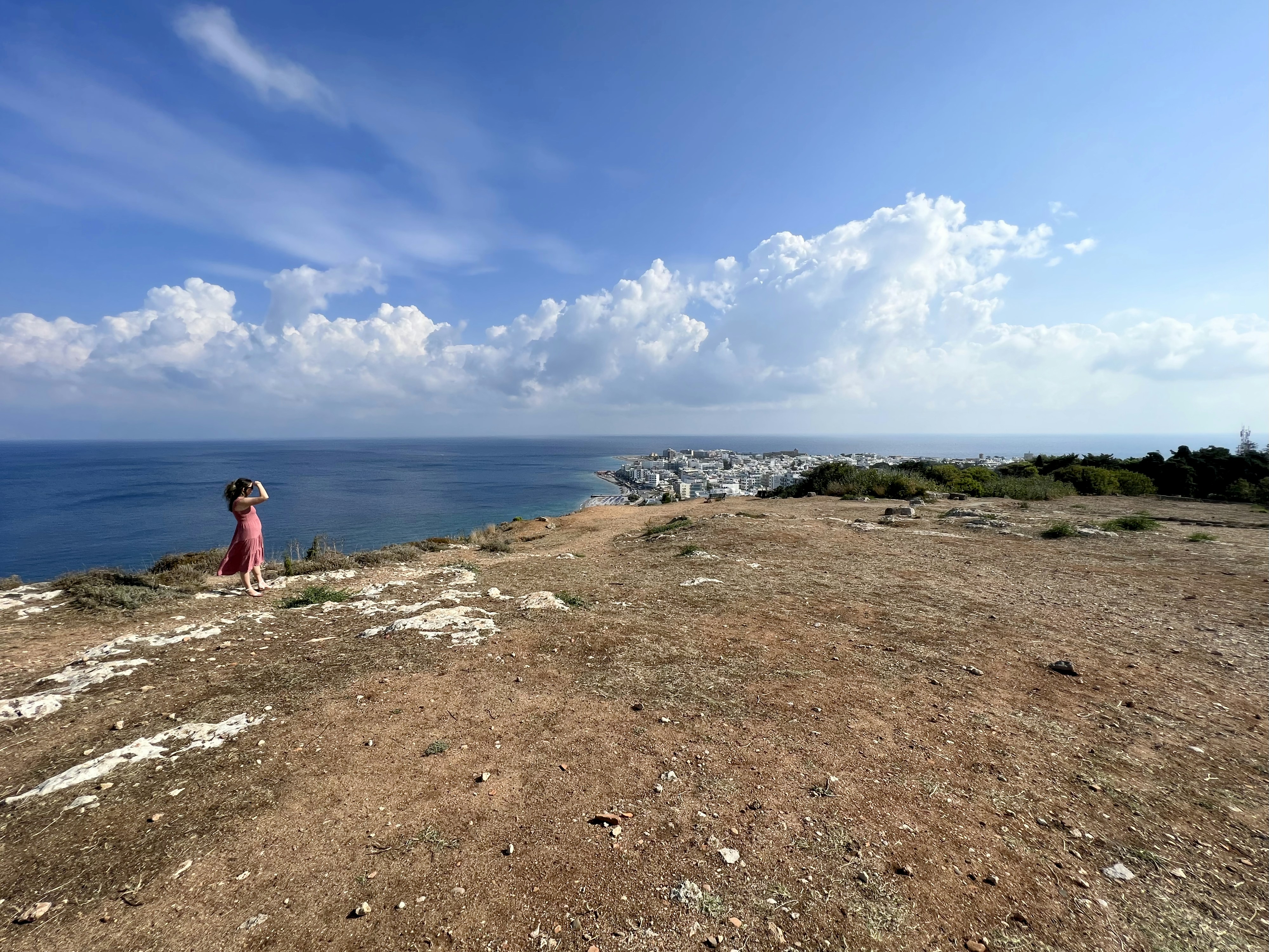 a person standing on top of a hill near the ocean