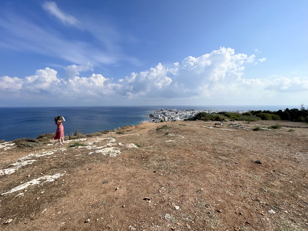 a person standing on top of a hill near the ocean