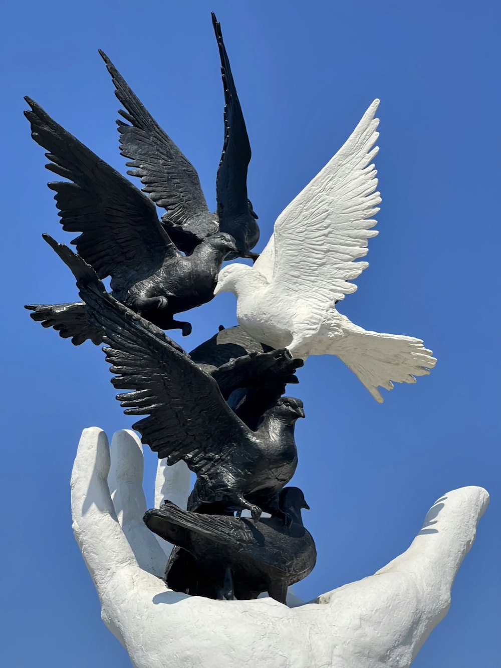 a statue of a hand holding two birds
