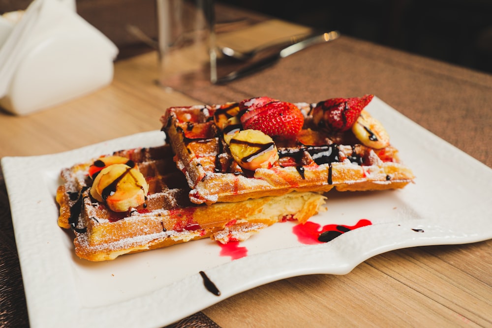 a plate of waffles with fruit on top