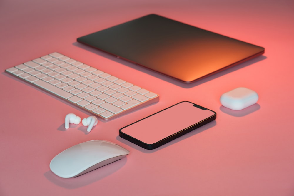 컴퓨터 마우스, 키보드 및 기타 전자 제품이 분홍색 표면에 표시됨