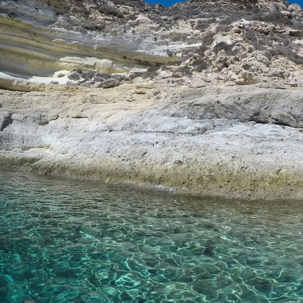 a body of water surrounded by rocks and sand