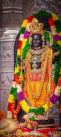 a statue of a hindu god surrounded by flowers