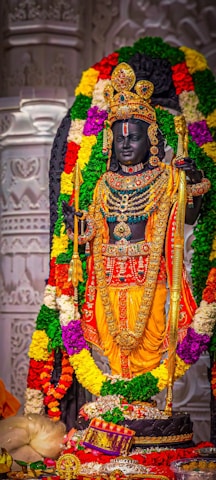 a statue of a hindu god surrounded by flowers