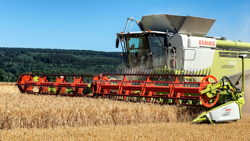 a combine of grain being harvested in a field