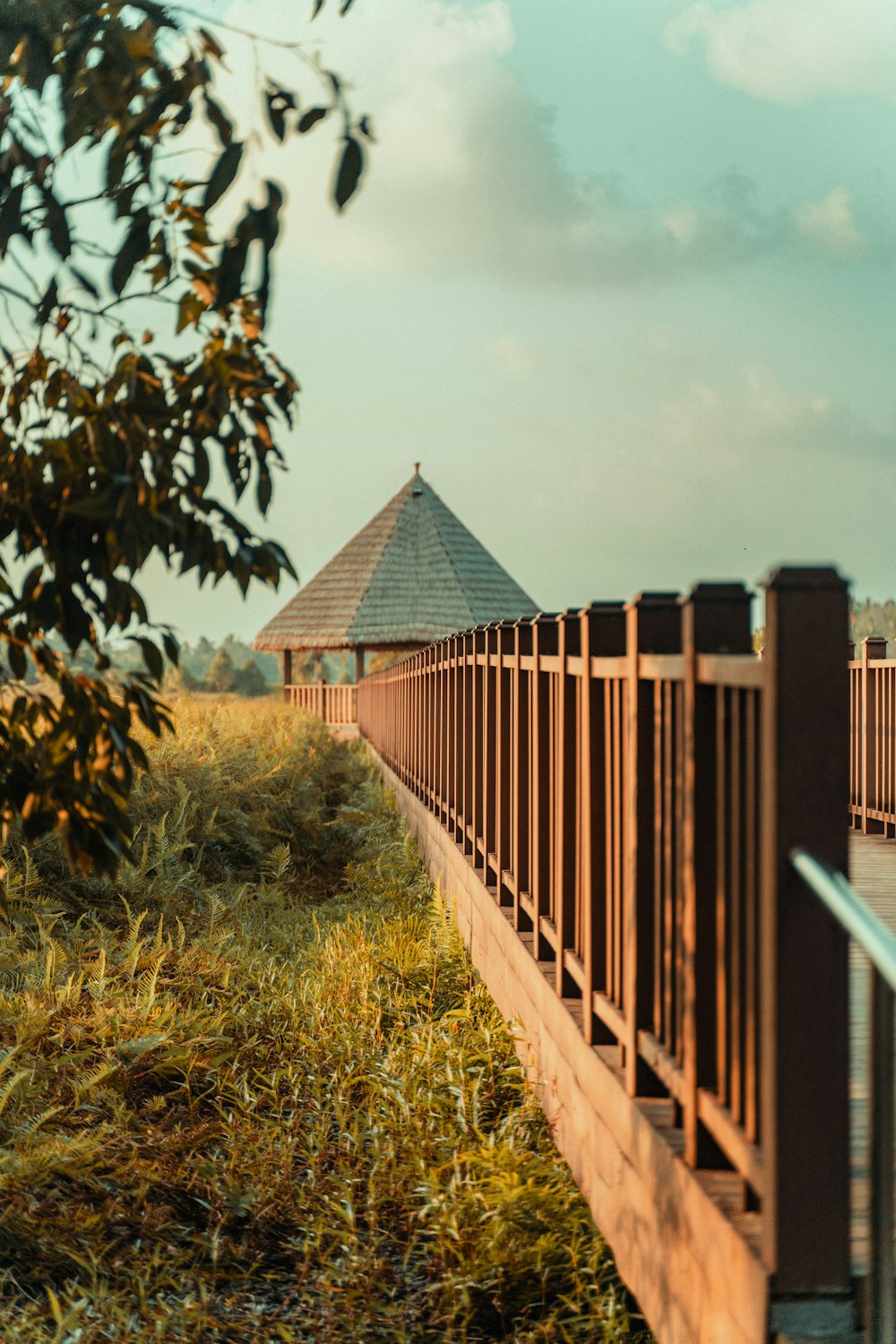 eine Holzbrücke mit einem Pavillon im Hintergrund