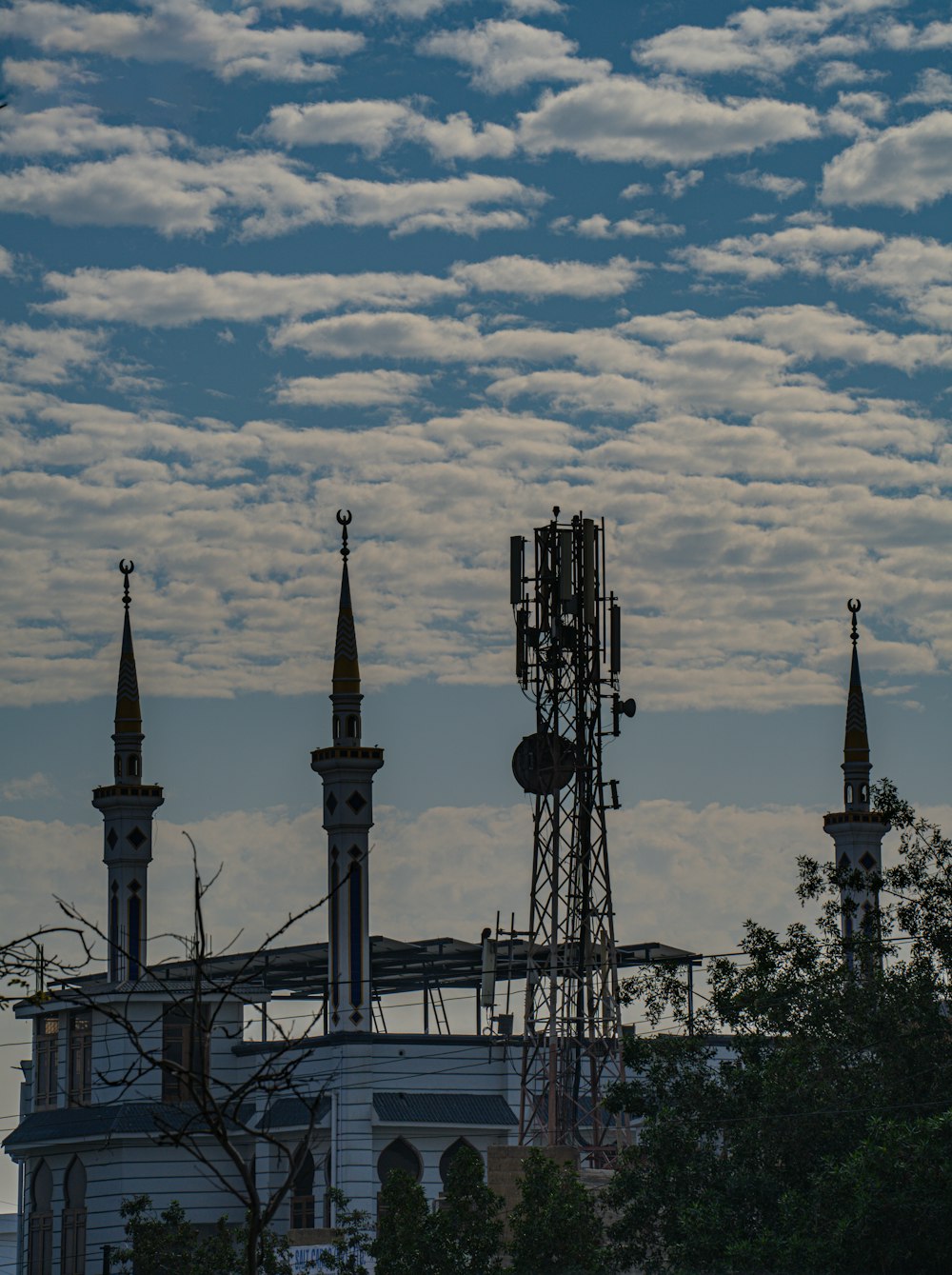 une vue d’un bâtiment avec une tour de téléphonie cellulaire au premier plan ;