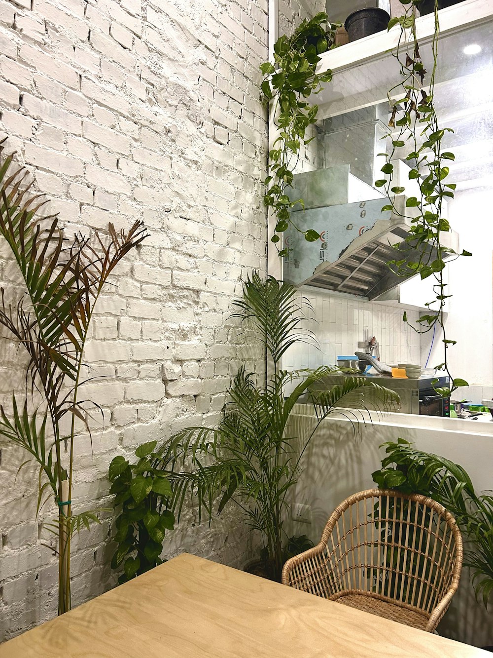 a wooden table sitting next to a white brick wall