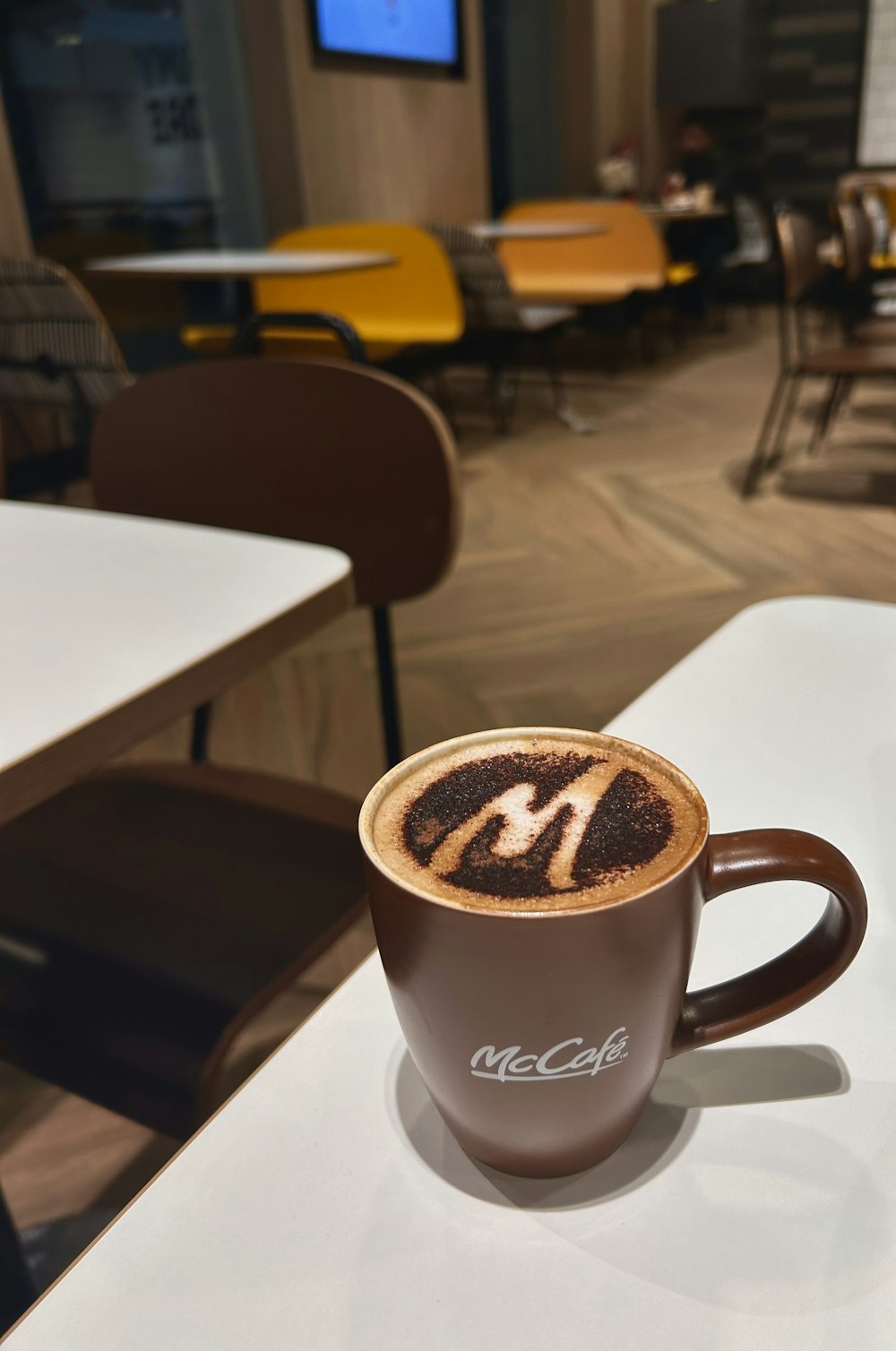 Un capuchino está sentado en una mesa en una cafetería