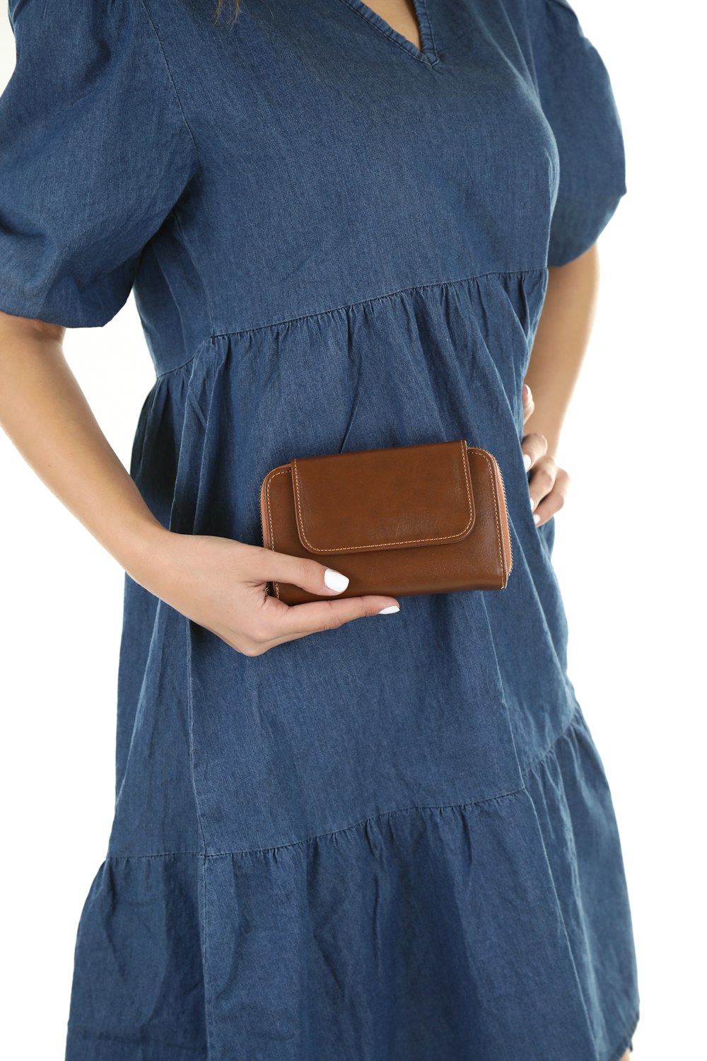 a woman in a blue dress holding a brown purse