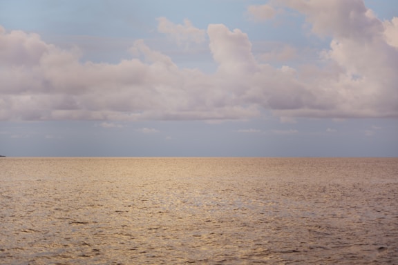 a large body of water under a cloudy sky